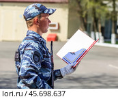 Молодой курсант МВД принимает присягу на площади. Полицеский читает текст присяги. (2019 год). Редакционное фото, фотограф Евгений Зимин / Фотобанк Лори