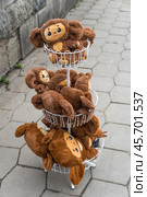 Resort town Kislovodsk, Stavropol Krai, Russia: March 27, 2023: Soft plush toys Cheburashka in basket in front of store on street. Редакционное фото, фотограф Алексей Антипов / Фотобанк Лори