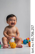 Adorable baby laughing and playing with colorful toys in joyful sequence. Стоковое AI-видео, аниматор Sabyna75 / Фотобанк Лори