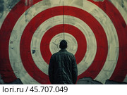 Man standing in front of target painted on wall. Стоковое AI-изображение, AI-художник Иван Рябоконь / Фотобанк Лори