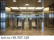 Empty turnstiles guarding entrance to office building with elevators. Стоковое AI-изображение, AI-художник Иван Рябоконь / Фотобанк Лори