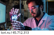 Engineer tests robotic hand with advanced technology in a modern lab setting. Стоковое AI-изображение, AI-художник Сергей Толмачёв / Фотобанк Лори