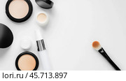 Makeup products arranged neatly on a white background with a brush and containers displayed for easy access. Стоковое AI-изображение, AI-художник Сергей Толмачёв / Фотобанк Лори