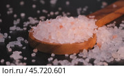 Himalayan pink salt in a wooden is used to flavor food. Due mainly to marketing costs, pink Himalayan salt is up to twenty times more expensive than table or sea salt. Стоковое видео, видеограф Андрей Армягов / Фотобанк Лори
