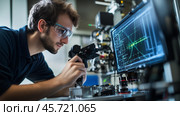 Engineer working on advanced technology in a modern laboratory environment during the day. Стоковое AI-изображение, AI-художник Сергей Толмачёв / Фотобанк Лори