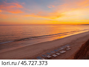Seaside holidays concept. Deserted sandy beach of the Atlantic Ocean at sunset. Scenic landscape. Natural sea background. Vilamoura, Falesia, Algarve, Portugal (2012 год). Стоковое фото, фотограф Виктория Катьянова / Фотобанк Лори