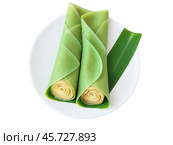 Dadar Gulung, pandan-flavored crepes filled with grated coconut and palm sugar, rolled and sliced, served on banana leaf, Indonesian delicacy, Стоковое AI-изображение, AI-художник svetograph / Фотобанк Лори
