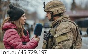 Female journalist interviewing soldier in uniform outdoors. Стоковое AI-видео, аниматор Юрий Поздников / Фотобанк Лори