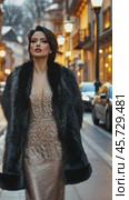 Elegant woman wearing fur stole walking down city street at dusk. Стоковое AI-видео, аниматор Юрий Поздников / Фотобанк Лори