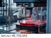 Bioprinting machine depositing bioink in petri dish for regenerative medicine. Стоковое AI-изображение, AI-художник Иван Рябоконь / Фотобанк Лори