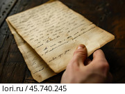 Historian reading ancient handwritten letter on wooden table. Стоковое AI-изображение, AI-художник Иван Рябоконь / Фотобанк Лори