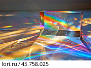 Glass prism refracting sunlight creating rainbow colors and abstract light patterns. Стоковое AI-изображение, AI-художник Иван Рябоконь / Фотобанк Лори