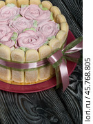 Cake with Savoiardi cookies and marshmallow roses. Tied with ribbon. The ribbon is tied into a bow. Стоковое фото, фотограф Vadzim Yakubovich / Фотобанк Лори