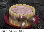 Cake with Savoiardi cookies and marshmallow roses. Tied with ribbon. The ribbon is tied into a bow. Стоковое фото, фотограф Vadzim Yakubovich / Фотобанк Лори