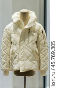White padded winter jacket displayed on mannequin in fashion retail store. Стоковое AI-изображение, AI-художник Юрий Поздников / Фотобанк Лори
