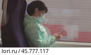 Woman wearing a protective medical face mask rides on a train during the covid 19 quarantine. Стоковое видео, видеограф Андрей Армягов / Фотобанк Лори