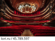 Elegant theater interior showcasing chandeliers and plush seating in a grand setting. Стоковое AI-изображение, AI-художник Юлия Гапеенко / Фотобанк Лори