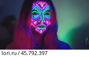 Woman wearing glowing neon makeup posing in the dark. Стоковое видео, видеограф Данил Руденко / Фотобанк Лори