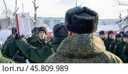 Maykop, Russia - January 13, 2024: A young soldier takes the military oath on the parade ground in front of a line of soldiers on a winter morning. Редакционное фото, фотограф Андрей С / Фотобанк Лори