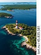 Aerial view of landscape of archipelago of islands with lighthouse in north sea, skyline at blue sky background. Amazing natural wild scenery view of Scandinavian nature concept. Copy ad text space. Стоковое AI-изображение, AI-художник Aleksandr Golubev / Фотобанк Лори