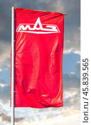 Dealership flag of Minsk Automobile Plant (MAZ) against a sky. MAZ is a Belarusian automaker. Редакционное фото, фотограф FotograFF / Фотобанк Лори