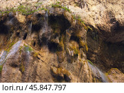 A rock with trickles of water seeping from cracks. Picturesque natural background. Copy space. Стоковое фото, фотограф Роман Дзюбало / Фотобанк Лори