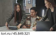 Two female employees demonstrate to the boss the benefits of using laptops for running a modern business. Стоковое видео, видеограф Strunov David / Фотобанк Лори