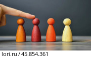 Human hand is pointing at an array of colorful wood game pieces, human figures. Choice and strategy in play or business. Finger points at a wooden figurines standing in a row. Leadership, community. Стоковое AI-видео, аниматор Марина Демидюк / Фотобанк Лори