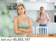 Upset woman standing in home kitchen after quarrel with teenage daughter. Стоковое фото, фотограф Яков Филимонов / Фотобанк Лори