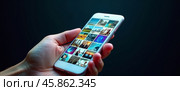 Hand with smartphone on black background. There are many different images on the screen. Copy space. AI generative. Стоковое AI-изображение, AI-художник Роман Дзюбало / Фотобанк Лори