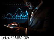 Businessman analyzing financial market data on tablet with stock chart displayed on screen. Стоковое AI-изображение, AI-художник Иван Рябоконь / Фотобанк Лори