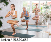 Teenage girl standing in balancing asana Eka Pada Utkatasana in yoga studio. Стоковое фото, фотограф Яков Филимонов / Фотобанк Лори