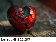 Broken heart representing lost love and sadness sitting on rustic wood. Стоковое AI-изображение, AI-художник Иван Рябоконь / Фотобанк Лори