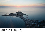 A picturesque panoramic sunset view of the peninsula and small island of the seaside village of Bolshoi Utrish. The water surface is colored by the rays of the setting sun. Aerial photography. Стоковое фото, фотограф Роман Дзюбало / Фотобанк Лори