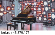 Grand piano on stage with lighting equipment ready for a concert. Стоковое AI-видео, аниматор Юрий Поздников / Фотобанк Лори