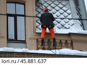 Очистка от снега крыши памятника архитектуры, объекта культурного наследия федерального значения "Дом К.А. Горчакова" на Большой Монетной улице промышленными альпинистами. Стоковое фото, фотограф Сергей Шелагин / Фотобанк Лори
