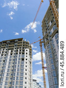 Строящееся высотное здание и подъемный кран на фоне голубого неба. Building crane and building under construction against blue sky. Стоковое фото, фотограф Татьяна Д / Фотобанк Лори