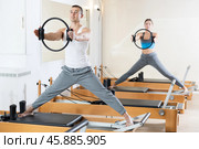 Man doing Pilates exercises with flexible ring on reformer. Стоковое фото, фотограф Яков Филимонов / Фотобанк Лори