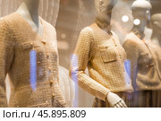 An elegant showcase of an expensive luxury store with stylish mannequins in clothes and evening lighting. The concept of shopping and sales. Стоковое фото, фотограф Photojuli / Фотобанк Лори