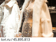 Blurred background. An elegant showcase of an elite store with stylish mannequins in clothes and evening lighting. The concept of shopping and sales. Стоковое фото, фотограф Photojuli / Фотобанк Лори