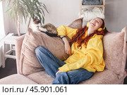 Peaceful teen girl in modern headphones sit relax on comfortable couch listening to music. Стоковое фото, фотограф Гладских Татьяна / Фотобанк Лори