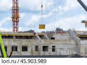 Строящееся высотное здание и подъемный кран на фоне голубого неба. Building crane and building under construction against blue sky. Стоковое фото, фотограф Татьяна Д / Фотобанк Лори