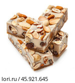 Delicious nougat bars covered with nuts and chocolate are lying on each other. Стоковое AI-изображение, AI-художник Иван Рябоконь / Фотобанк Лори