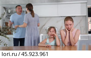 Worried teenage girls, filled with disappointment, shielding ears, refusing to hear scolding of mother and father standing in background. Selective focus on quarreling parents. Стоковое видео, видеограф Яков Филимонов / Фотобанк Лори