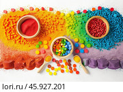 Colorful sensory play setup with rainbow-colored granules, wooden bowls, and spoons. Educational hands-on activity for creativity and exploration. Стоковое AI-изображение, AI-художник Екатерина Каболова / Фотобанк Лори