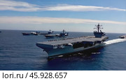 Aircraft carrier navigating with escort ships in the ocean. Стоковое видео, видеограф Данил Руденко / Фотобанк Лори