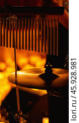 Close-up of a drum set with a cymbal and chimes in the foreground. The background is blurred and orange. Стоковое фото, фотограф Воловодов Владимир / Фотобанк Лори