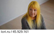 Senior woman with dyed yellow hair looking away. Стоковое видео, видеограф Данил Руденко / Фотобанк Лори