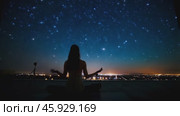 Woman meditating under starry night sky. Стоковое видео, видеограф Данил Руденко / Фотобанк Лори