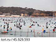 Китайцы катаются на коньках в выходной день на озере Kunming Lake у Летнего дворца в Пекине, Китай (2024 год). Редакционное фото, фотограф Кекяляйнен Андрей / Фотобанк Лори